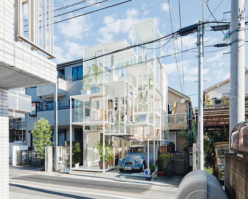 藤本壯介House NA的白色框架與透明外牆,藍色小車停在入口旁的上層平台下方