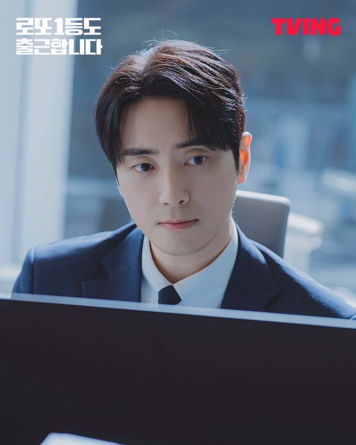 李浚赫穿西裝坐在電腦螢幕前,演出《中頭獎還是要上班》的上班族