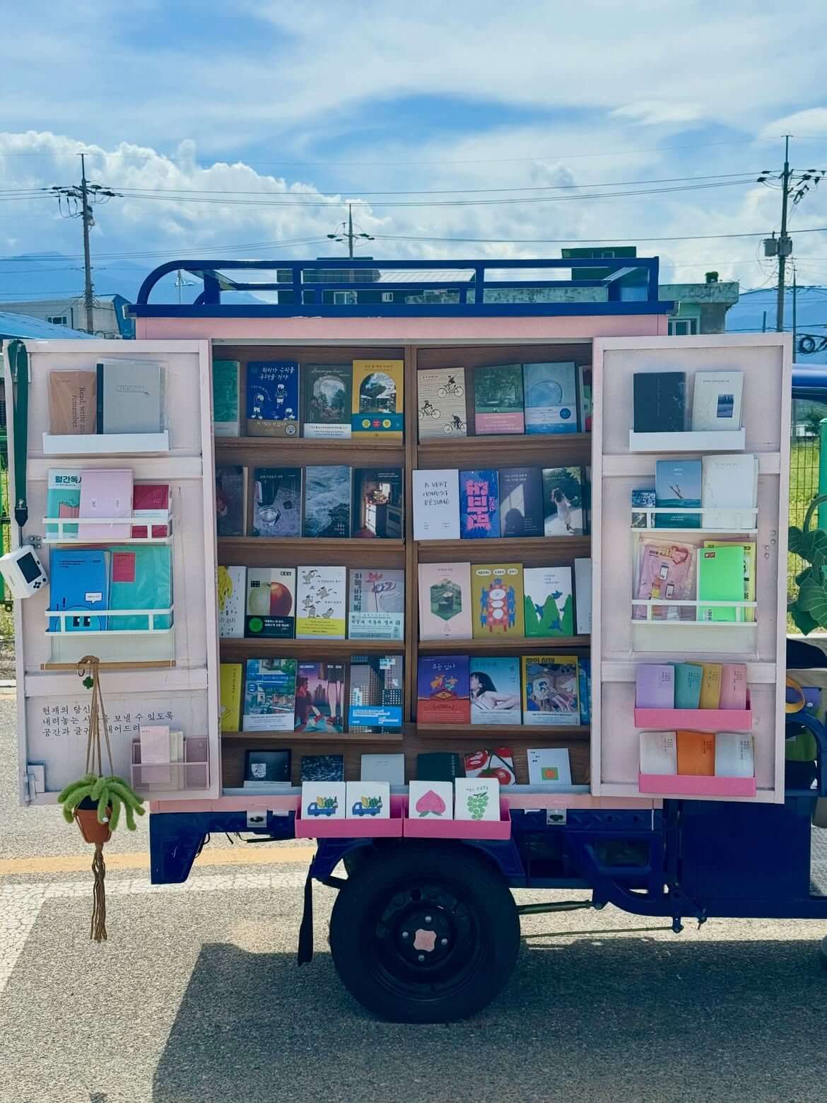 Three Feet Bookstore 車廂打開後,木層架與粉色門片上陳列不同書籍。