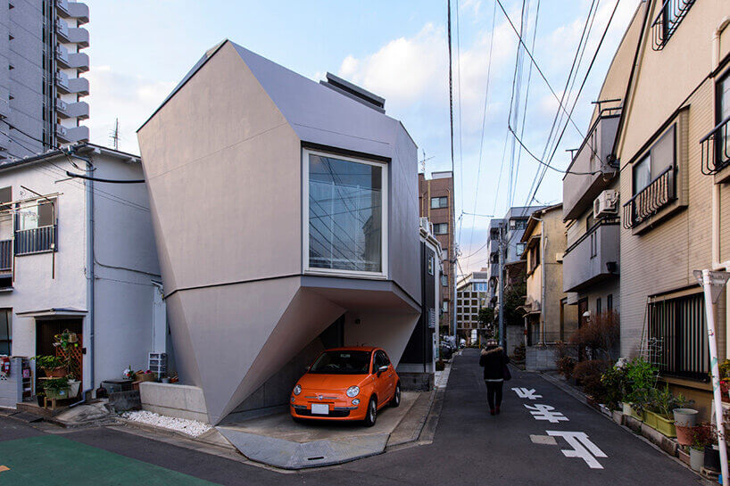 東京Reflection of Mineral白色多面體住宅，橘色小車停在量體下方的遮蔽凹口